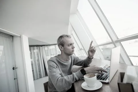 Freelancer got stuck in his work. Young concentrated man in casual clothes with Stock Photos