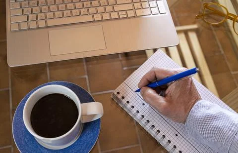 Freelancer hand writing notes working remote from home 스톡 사진