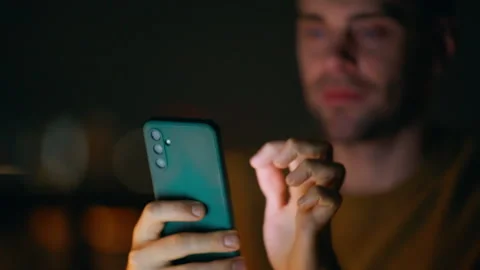 Freelancer hands typing sms at cellphone in dark apartment closeup. Man tapping Stock Footage 340116671
