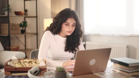 Freelancer having distance remote work and eating pizza at home Stock Footage 251732356