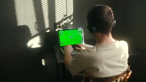 Freelancer in headphones working on a green screen laptop Stock Footage 337831192
