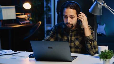 Freelancer listening music while doing computer tasks in home office Foto stock
