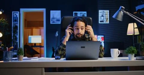 Freelancer listening music while doing computer tasks in home office Foto stock