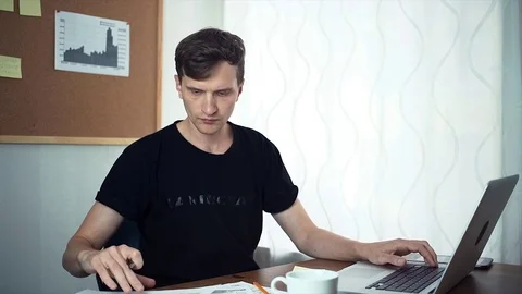 Freelancer looking at printed data and analyzing graphs at the home office Stock Footage 79895968