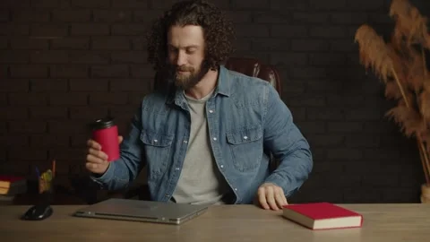 Freelancer man with a beard come at the workplace in the office and are happy Stock Footage 253630422