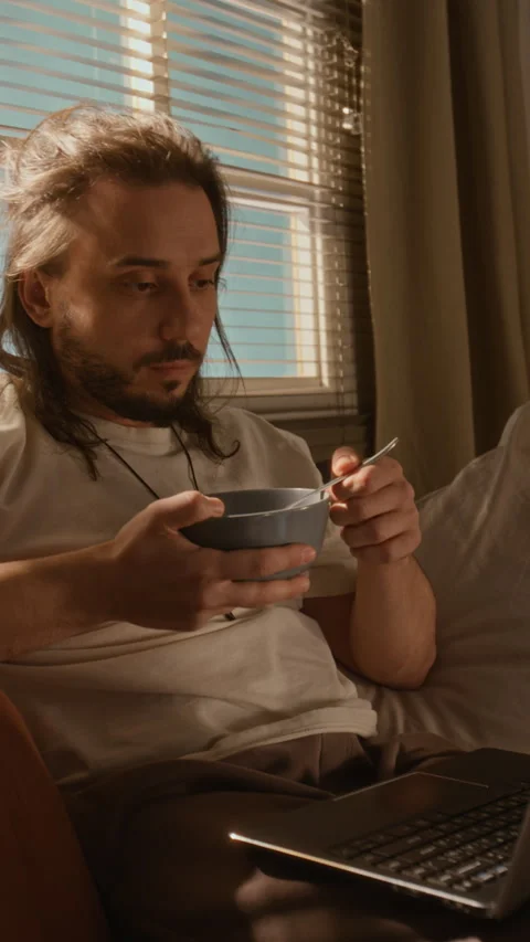 Freelancer Man Eating Breakfast and Working on Laptop in Morning Stock Footage 337510189