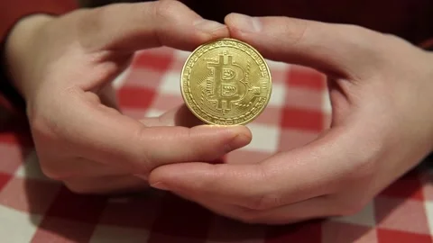 Freelancer man holds in her hands a gold coin symbol of bitcoin. Stock-Footage 170012980