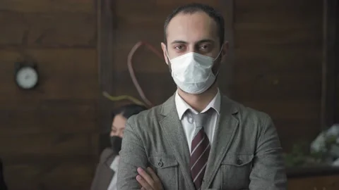 Freelancer man in protective mask standing in front of colleagues with arms Stock Footage 131043971