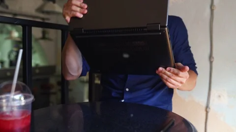 Freelancer man transforms convertible laptop to tablet mode and works with Stock Footage 122673473