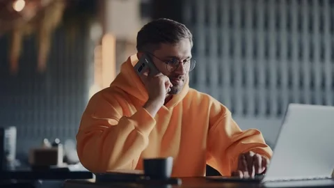 Freelancer Man Using Laptop And Mobile Phone When Sitting Alone In Cafe Stock-Footage 343354631