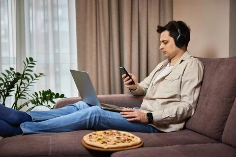 Freelancer man using smart phone and laptop Stock Photos