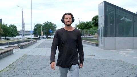 Freelancer Man walking in the big urban city working with a laptop phone camera Stock Footage 114497409