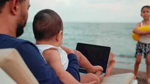 Freelancer man working on laptop and looking after children. Remote work concept Stock Footage 204860376