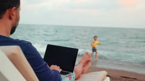 Freelancer man working on laptop and looking after the child. Remote work Video stock 204860424