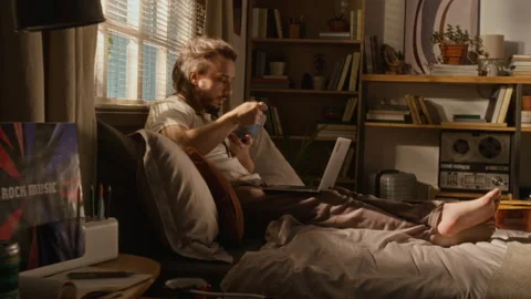 Freelancer Man Working Remotely on Laptop while Eating Breakfast in Bed Stock Footage 337505338