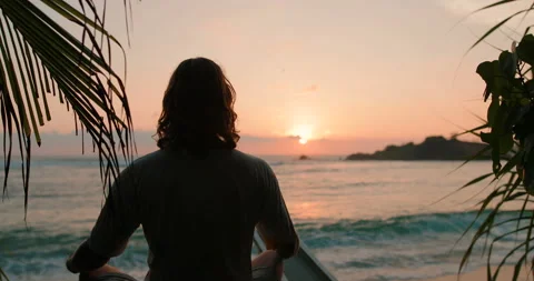 Freelancer is meditating on the ocean at sunset Stock Footage 105736624