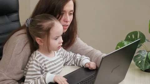 Freelancer Mom and child work on the computer remotely at home. Mother works Stock Footage 148447011