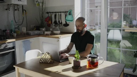 Freelancer programmer working from home on kitchen and using laptop. Bearded man Stock Footage 135731977