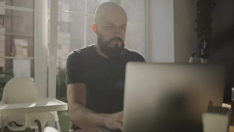 Freelancer programmer working from home on kitchen and using laptop. Bearded man Stock Footage 135732047