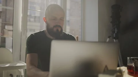 Freelancer programmer working from home on kitchen and using laptop. Bearded man Stock Footage 135732078