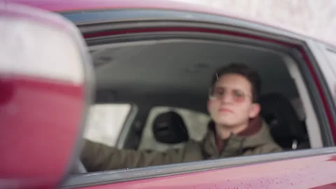 Freelancer rolling down car window during winter with snowflakes on glass Stock Footage 310180438
