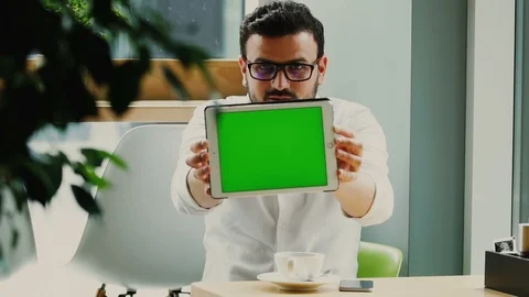 Freelancer sitting with cup of coffee and showing his digital tablet with Stock Footage 112990282
