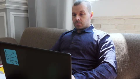 Freelancer sitting on a sofa working on a laptop. Stock Footage 133445680