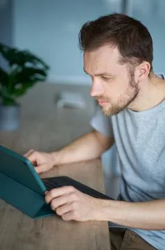 Freelancer software developer male using tablet device to learn or work online Stock Photos
