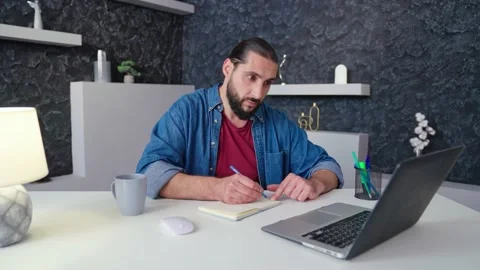 Freelancer taking notes in front of laptop watch the webinar online course Stock Footage 236588147