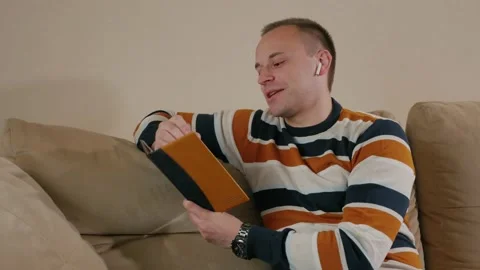 Freelancer talking in wireless headphones in home. Stock Footage 130861565