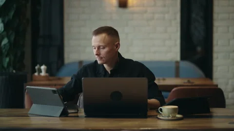 Freelancer Trader Working With Laptop In Cafe, Monitoring Stock Market On Stock Footage 243311980