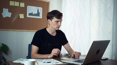Freelancer using laptop and writing ideason sticky notes at office Video stock 79895401