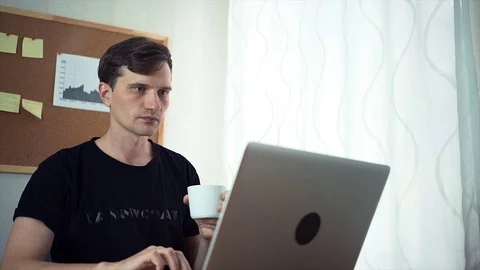 Freelancer using laptop computer and drinking coffee in the home office. Stock Footage 79896229