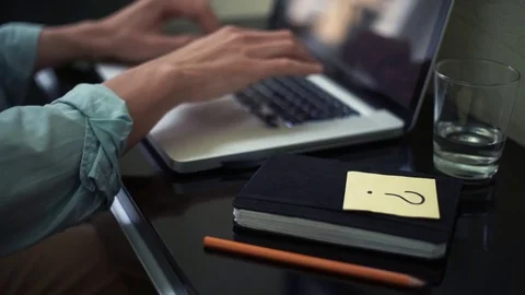 Freelancer using laptop at home. Sticky note with question sign on desk Stock Footage 82926958