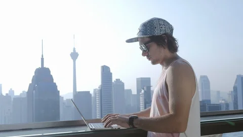 Freelancer using laptop on modern city background during summer vacation. Stock Footage 106619054