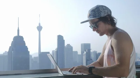 Freelancer using laptop on modern city background during summer vacation. Stock Footage 106619244