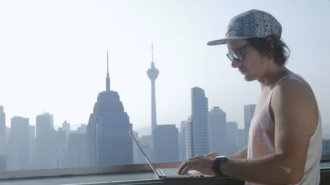 Freelancer using laptop on modern city background during summer vacation. Stock Footage 106619649