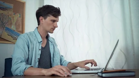 Freelancer using laptop at office. Board with color sketches at wall behind Video stock 79901786