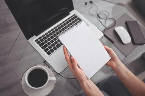 Freelancer using smart phone and laptop at home during quarantine. Stock Photos