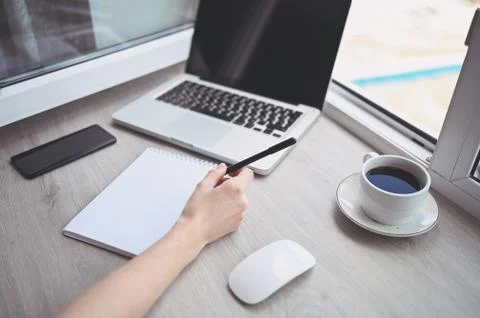 Freelancer using smart phone and laptop at home during quarantine. Stock Photos