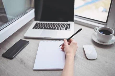 Freelancer using smart phone and laptop at home during quarantine. Stock Photos