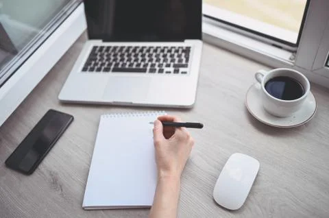 Freelancer using smart phone and laptop at home during quarantine. Stock Photos