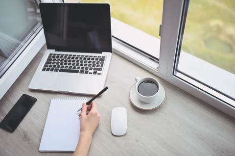Freelancer using smart phone and laptop at home during quarantine. Stock-Fotos