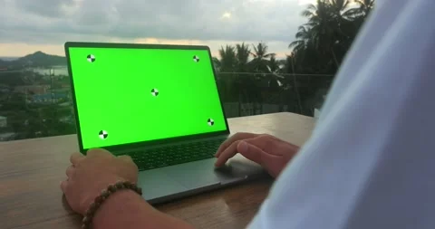 Freelancer using touchpad on laptop computer with green mockup on background of Stock Footage 237356157