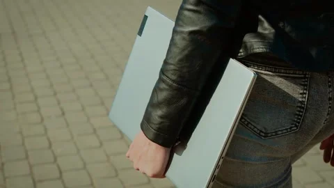 Freelancer walking with closed laptop. Remote worker carrying portable computer Stock Footage 314105668