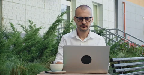 Freelancer wearing glasses actively texting on laptop Stockbeeldmateriaal 253377759