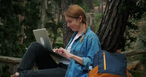 Freelancer woman using laptop in forest during hiking and traveling. Stock Footage 151856479