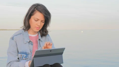 Freelancer woman working in her notebook on sea coastline Stockbeeldmateriaal 111393837