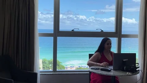 Freelancer woman working online while enjoying ocean view vacation Brazil Vidéo 330897435