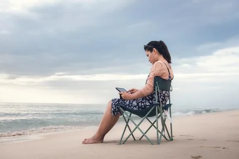 Freelancer Woman is Working on Tablet While Travel Vacation Trip at The Beach Stock Photos